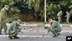 Na ovoj fotografiji napravljenoj od video-snimka Istražnog komiteta Rusije u nedelju, 21. avgusta 2022, istražitelji rade na mestu eksplozije automobila koji je vozila Darija Dugina, nedaleko od Moskve.