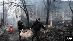 Petugas polisi memindahkan mayat seorang korban tewas dalam serangan Rusia pada sebuah menara televisi di Kyiv, Ukraina, pada 2 Maret 2022. (Foto: AFP/Aris Messinis)