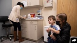 FILE - Ilana Diener holds her son, Hudson, 3, during an appointment for a Moderna COVID-19 vaccine trial in Commack, N.Y. on Nov. 30, 2021.