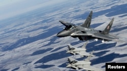 Літак військово-повітряних сил Польщі (згори) MIG-29 та італійські літаки Eurofighter Typhoon під час патрулювання над Балтією 10 лютого 2015 р.
