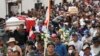 People walk in a funeral procession for Clemer Rojas, 23, who was killed during protests against new President Dina Boluarte, in Ayacucho, Peru, Dec. 17, 2022. 