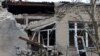 A woman measures size of a broken hospital window following recent shelling in the course of Russia-Ukraine conflict in Donetsk, Russian-controlled Ukraine, Dec. 15, 2022.