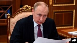 Presiden Rusia Vladimir Putin mendengarkan Gubernur Daerah Otonomi Yamalo-Nenets Dmitry Artukhov selama pertemuan mereka di Moskow, Rusia, Senin, 21 Maret 2022. (Foto: via AP)