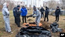 Francuski forenzičari pored masovne grobnice u gradu Buča, u Ukrajini.(Foto: AP/Wladyslaw Musiienko)
