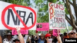 Masyarakat memprotes undang-undang senjata di luar gedung konvensi tahunan National Rifle Association (NRA) di Houston, Texas, AS 27 Mei 2022. (Foto: REUTERS/Daniel Kramer)