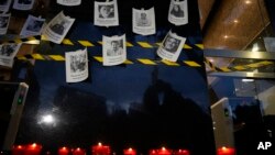 FILE - Photos of slain journalists on a wall during a vigil to protest the murder of journalist Fredid Roman, in Mexico City, Aug. 24, 2022. 