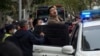 Polisi menahan seorang demonstran dalam aksi protes menentang aturan pembatasan terkait COVID di Shanghai, China, pada 27 November 2022. (Foto: AP)