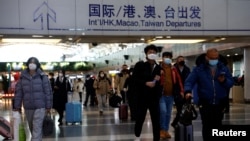 Sejumlah penumpang berjalan sambil membawa kopernya di Bandara Internasional Beijing, di tengah perebakan COVID-19 di negara tersebut, pada 27 Desember 2022. (Foto: Reuters/Tingshu Wang)