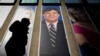 Archivo- La gente pasa junto a una promoción del presentador de Fox News, Tucker Carlson, en el edificio de News Corporation en Nueva York.