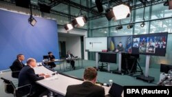 Presiden Ukraina Volodymyr Zelenskiy muncul di layar saat Kanselir Jerman Olaf Scholz menghadiri pertemuan para pemimpin G7 virtual di Kanselir di Berlin, Jerman, 11 Oktober 2022. (Steffen Kugler/BPA/Handout via REUTERS)