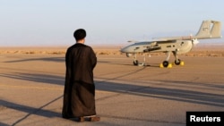 Seorang ulama Iran memperhatikan pesawat nir awak dalam latihan militer di lokasi yang tidak diungkap di Iran dalam foto yang dirilis pada 24 Agustus 2022. (Foto: Militer Iran/WANA (West Asia News Agency) via Reuters)
