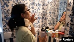 Lauren Nichols, yang memiliki gejala long COVID, menelan obat untuk gejala yang ia derita di rumahnya di Andover, Massachusetts, pada 3 Agustus 2022. (Foto: Reuters/Lauren Owens Lambert)