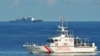 FILE - Kapal penjaga pantai Filipina (kanan) berlayar melewati kapal penjaga pantai China selama latihan pencarian dan penyelamatan bersama antara penjaga pantai Filipina dan AS di dekat Beting Scarborough di Laut Cina Selatan, 14 Mei 2019.