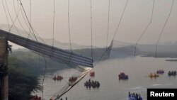 Rescuers search for survivors after a suspension bridge collapsed in Morbi town in the western state of Gujarat, India, Oct. 31, 2022. 