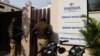 FILE - Police is seen at the gate of an office of Marion Biotech, a health care and pharmaceutical company and a part of the Emenox Group, whose cough syrup has been linked to the deaths of children in Uzbekistan, in Noida, India, Dec. 29, 2022.