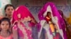 FILE - In this April 17, 2017, photo, an underaged bride, right, stands with family members during her marriage at a Hindu temple near Rajgarh, Madhya Pradesh state, India.