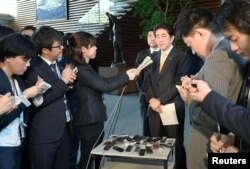 FILE - Japan's Prime Minister Shinzo Abe speaks to reporters at his office in this photo taken by Kyodo, in Tokyo, Japan, April 24, 2017, after speaking with U.S. President Donald Trump on the phone.
