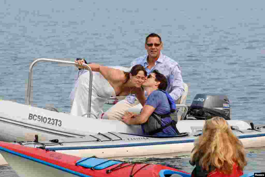 Newlyweds Michelle and Heiner Gruetzner, who were holding their wedding reception nearby, meet Canada&#39;s Prime Minister Justin Trudeau while he was kayaking off Sidney, British Columbia, Canada, Aug. 5, 2017.