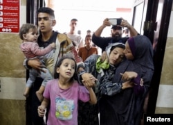 Warga Palestina berusaha menyelamatkan diri usai serangan Israel di sebuah rumah sakit di Khan Younis di selatan Jalur Gaza, 13 November 2023. (Foto: REUTERS/Mohammed Salem)