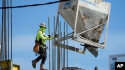 Pekerja konstruksi di Miami, 24 Januari 2023. Departemen Perdagangan mengeluarkan perkiraan pertama dari tiga perkiraan tentang kinerja ekonomi AS pada kuartal keempat tahun 2022.(AP/Lynne Sladky)