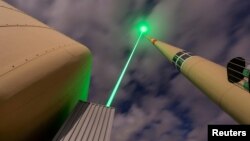 The Laser Lightning Rod, an experimental lightning protection device that diverts the path of lightning bolts using a high-power laser, is seen in action at the top of Mount Santis in Switzerland in this undated photograph. (TRUMPF/Martin Stollberg/Handout via Reuters)