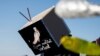 An Albanian environment activist wears an installation mask that reads, "I am not a virtual reality", during a protest against the new airport in the Vjose-Narte area in Vlora, Albania, Jan. 28, 2023. 