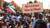 FILE - A protester holds a sign that reads, "France's army get out from our country," as people gather to show their support to Burkina Faso's new military leader Ibrahim Traore, in Ouagadougou, Burkina Faso, Jan. 20, 2023. 
