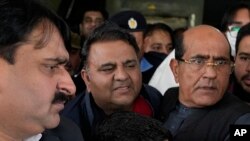 পাকিস্তানের লাহোরের একটি হাসপাতালে মেডিকেল চেকআপের পর সাবেক প্রধানমন্ত্রী ইমরান খানের দলের জ্যেষ্ঠ নেতা ফাওয়াদ চৌধুরীকে সাদা পোশাকে পুলিশ কর্মকর্তারা নিয়ে যাচ্ছেন। ( ২৫ জানুয়ারি, ২০২৩) 