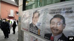 Posters of presidential candidates of Lee Jae-myung of the ruling Democratic Party and Yoon Suk Yeol, right, of the main opposition People Power Party are displayed at a local polling station in Seoul, South Korea, Friday, March 4, 2022. (AP Photo/Ahn Young-joon)