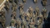 FILE - Myanmar soldiers walk along a street during a protest against the military coup in Yangon, Feb. 28, 2021.