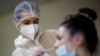 FILE - A medical worker administers a nasal swab to a patient at a COVID-19 testing center in Les Sorinieres, France, June 23, 2022. 