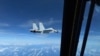 Sebuah jet tempur Angkatan Laut China J-11 terbang dekat dengan pesawat RC-135 Angkatan Udara AS di wilayah udara internasional di atas Laut China Selatan, pada 21 Desember 2022. (Foto: via Reuters )