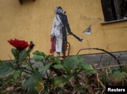 FILE - A mural in Banksy's signature style is seen on the wall of a destroyed building in the Ukrainian town of Hostomel, Nov. 13, 2022.