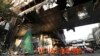 Cambodian and Thai rescue experts walk through a ruined building for a searching operation at the scene of a massive fire at a Cambodian hotel casino in Poipet, west of Phnom Penh, Cambodia, Dec. 30, 2022. 