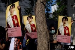 Pengunjuk rasa Burma membawa foto pemimpin sipil Myanmar Aung San Suu Kyi yang ditahan dalam aksi unjuk rasa di luar Kedutaan Besar Myanmar di Bangkok,19 Desember 2022. (Jack TAYLOR / AFP)