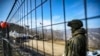FILE - A Russian peacekeeper guards the Lachin corridor, the Armenian-populated breakaway Nagorno-Karabakh region's only land link with Armenia, as Azerbaijani environmental activists protest against what they claim the illegal mining, Dec. 27, 2022.