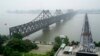FILE - Visitors cross the Yalu River Broken Bridge, right, next to the Friendship Bridge connecting China and North Korea in Dandong China, Sept. 9, 2017. North Korea and China resumed freight train service, Sept. 26, 2022, after a five-month hiatus, South Korean officials said.
