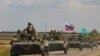 FILE - An armored convoy of Russian troops drives in Russian-held part of Zaporizhzhia region, Ukraine, July 23, 2022. 