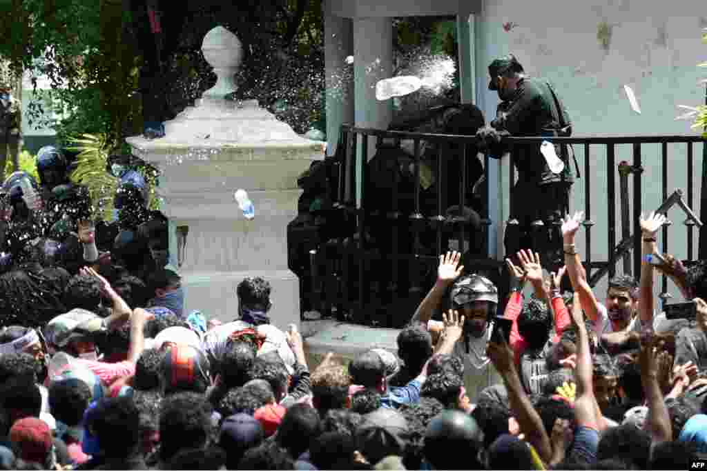 Demonstrators throw bottles of water to army personnel during an anti-government protest outside the office of Sri Lanka&#39;s prime minister in Colombo, July 13, 2022.&nbsp;Thousands of anti-government protesters stormed into Prime Minister Ranil Wickremesinghe&#39;s office, hours after he was named as acting president, witnesses said.&nbsp;