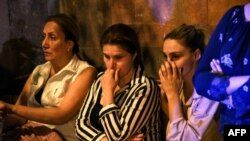 Relatives of servicemen, who were wounded in night border clashes between Armenia and Azerbaijan, gather outside a military hospital in Yerevan, Sept. 13, 2022. 