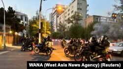 FILE - Police arrive to disperse demonstrators during a protest over the death of Mahsa Amini, a woman who died after being arrested by the Islamic republic's 'morality police', in Tehran, Iran, Sept. 19, 2022.