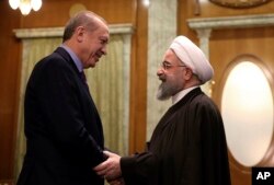 FILE - Turkey's President Recep Tayyip Erdogan, left, and Iran's President Hassan Rouhani greet each other before a meeting with Russia's President Vladimir Putin, in Sochi, Russia, Nov. 22. 2017.