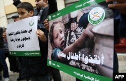 Children and Lebanese activists from the Islamic group Jamaa Islamiya hold a sit-in in solidarity with the Syrian besieged town of Madaya, outside the International Committee of the Red Cross (ICRC) headquarters in the Lebanese capital Beirut, Jan. 8, 201