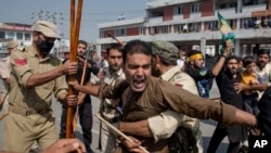 Seorang Muslim Syiah Kashmir meneriakkan slogan ketika polisi India menghentikannya untuk berpartisipasi dalam prosesi keagamaan di Srinagar tengah, Kashmir yang dikuasai India, Rabu, 19 September 2018.