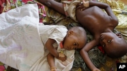 FILE - Two children stricken with malaria rest at the local hospital in the small village of Walikale, Congo.