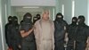 (FILES) This handout picture released by the Mexican Federal Preventive Police (PFP) shows members of the Federal Preventive Police guarding drug trafficker Rafael Caro Quintero (C) after an operation at the Puente Grande prison in Guadalajara, Jalisco, 4