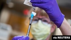 Seorang perawat mempersiapkan vaksin Covid-19 di UW Health, Madison, Wisconsin, Amerika Serikat, 14 Desember 2020. 