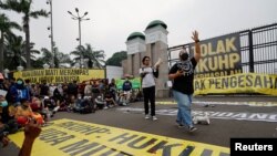 Seorang aktivis meneriakkan slogan-slogan saat memprotes peengesahkan KUHP, di luar gedung DPR di Jakarta, 5 Desember 2022. (Foto: REUTERS/Willy Kurniawan)