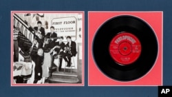 This undated photo provided by Heritage Auctions from an upcoming Beatles collection sale shows a signed copy of their first hit, “Love Me Do,” which will be auctioned in New York.