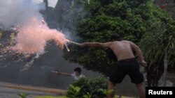 Supporters of Luis Fernando Camacho, the governor of Santa Cruz and a prominent opposition leader, fire firecrackers towards police officers during a protest following Camacho's detention by the Bolivian police, in Santa Cruz de la Sierra, Bolivia Dec. 28, 2022.